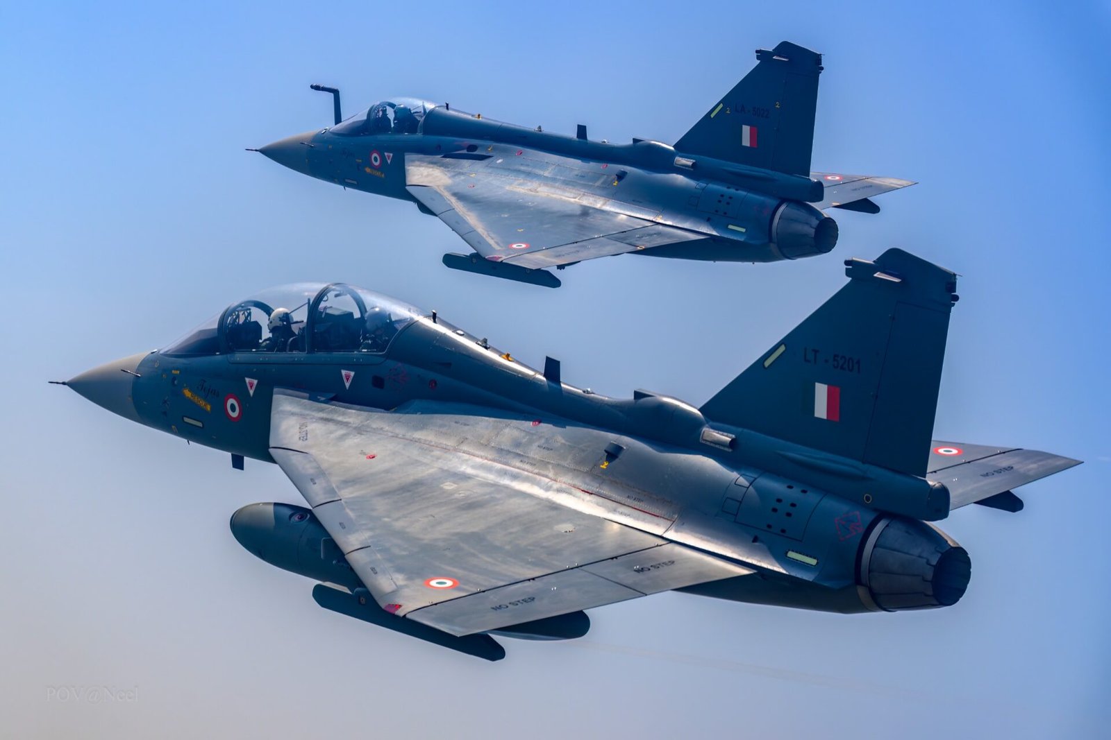 The image shows a Tejas Mk-1 trainer flying alonside a Tejas single-seat fighter